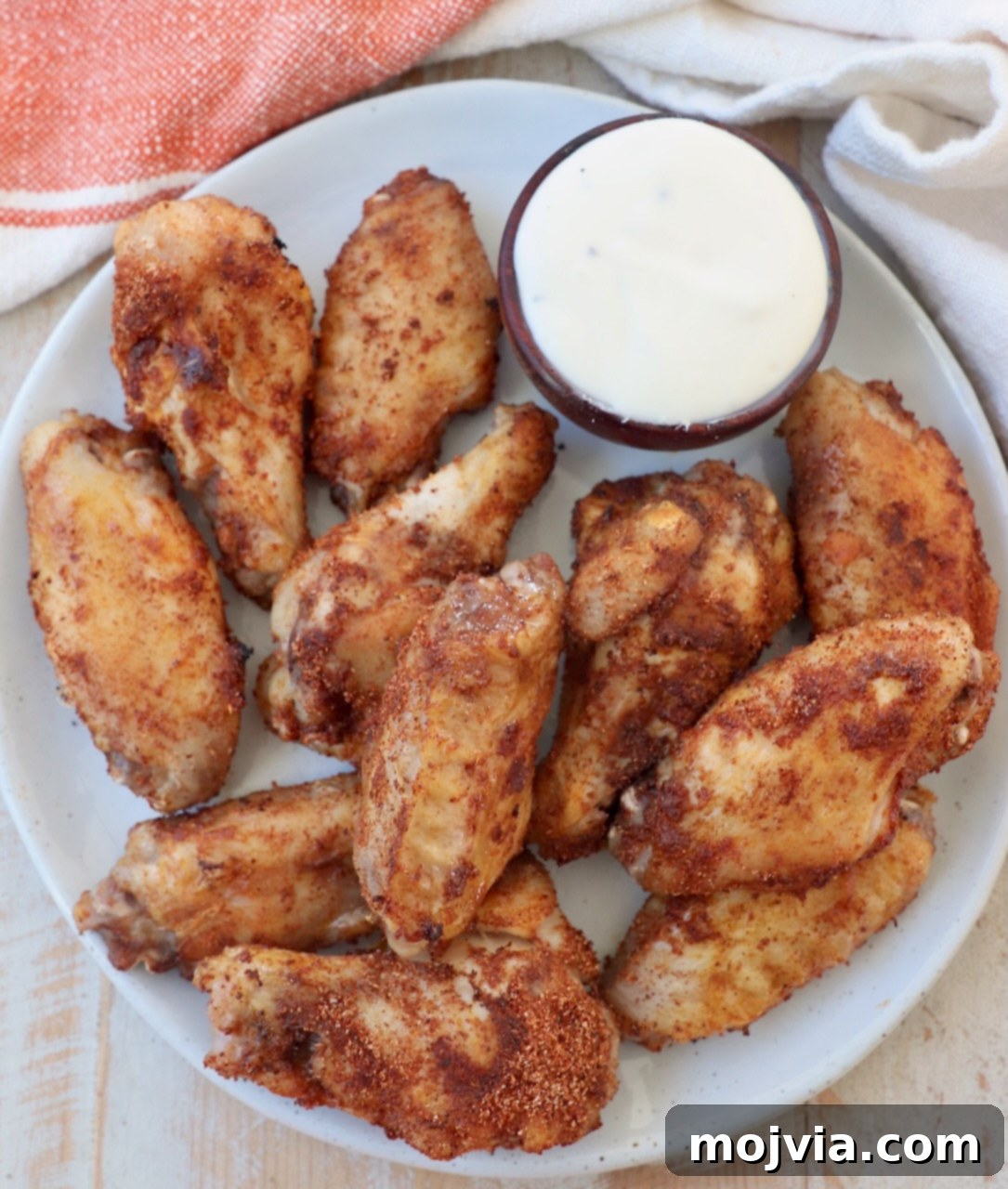 Sous Vide Wings: Crispy, Juicy Perfection 11 cooked chicken wings on plate with side of blue cheese dressing in small bowl