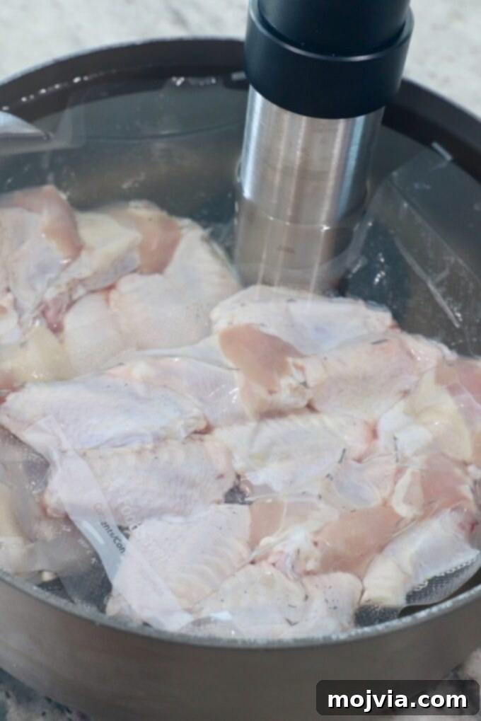 Sous Vide Wings: Crispy, Juicy Perfection 5 vacuum sealed bags of chicken wings in pot of water with sous vide attachment on the side