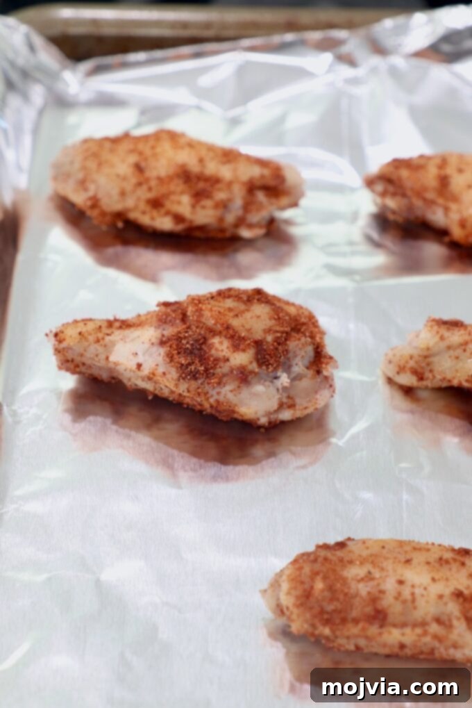 Sous Vide Wings: Crispy, Juicy Perfection 8 seasoned chicken wings on foil lined baking sheet