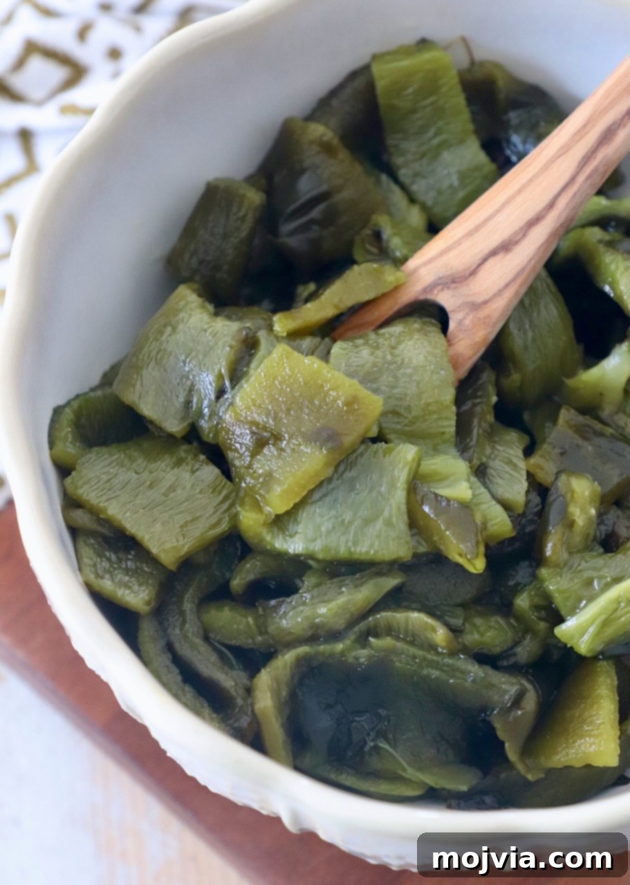 Smoky Roasted Poblanos 9 Diced roasted poblano peppers in a rustic wooden bowl with a wooden fork, ready to be incorporated into a dish.