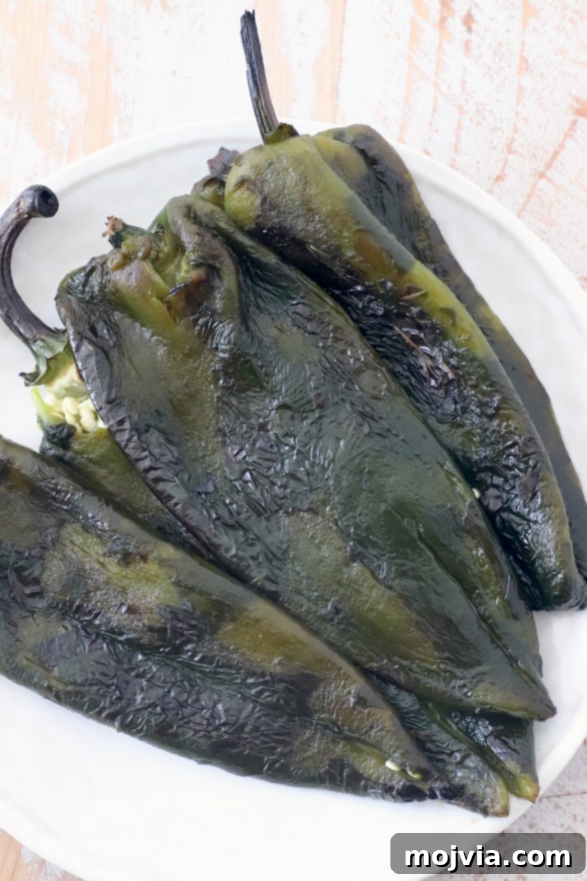 Smoky Roasted Poblanos 10 A serving of roasted poblano peppers on a clean white plate, garnished and ready to be enjoyed or incorporated into a meal.