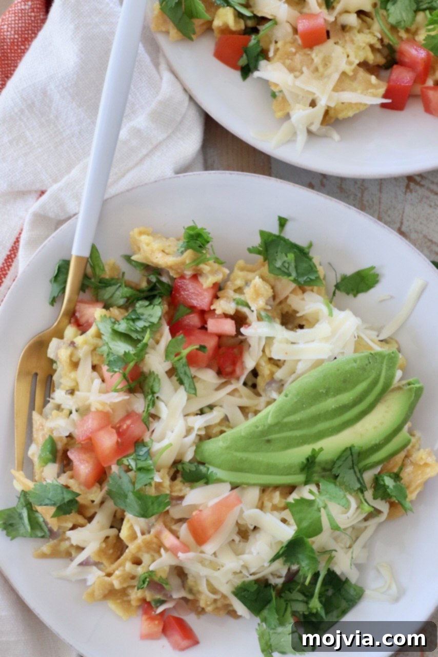 Classic Migas 2 A vibrant plate of Tex-Mex Migas topped with fresh sliced avocado, showcasing a perfect breakfast meal ready to be enjoyed.