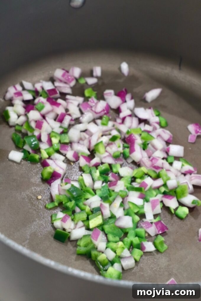 Classic Migas 5 Diced jalapeños and onions sautéing in a large skillet, forming the flavor base for Migas.