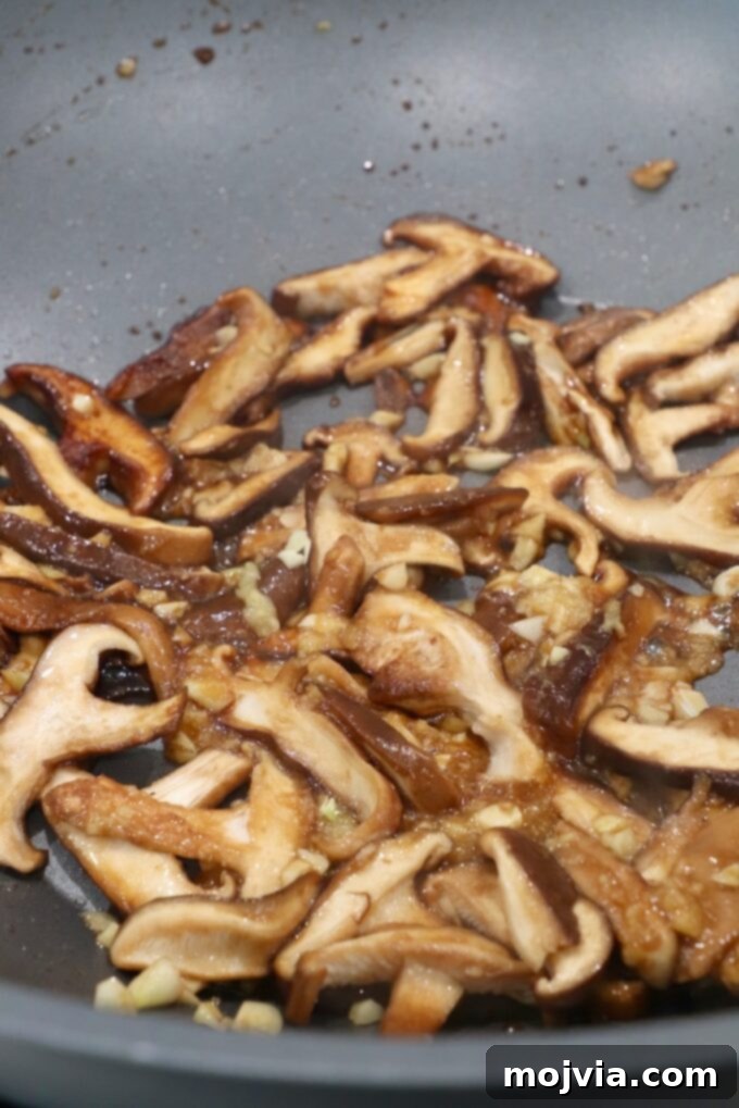 Golden Miso Noodle Perfection 6 Sautéed shiitake mushrooms gently browning in the wok, releasing their rich aroma and flavor.