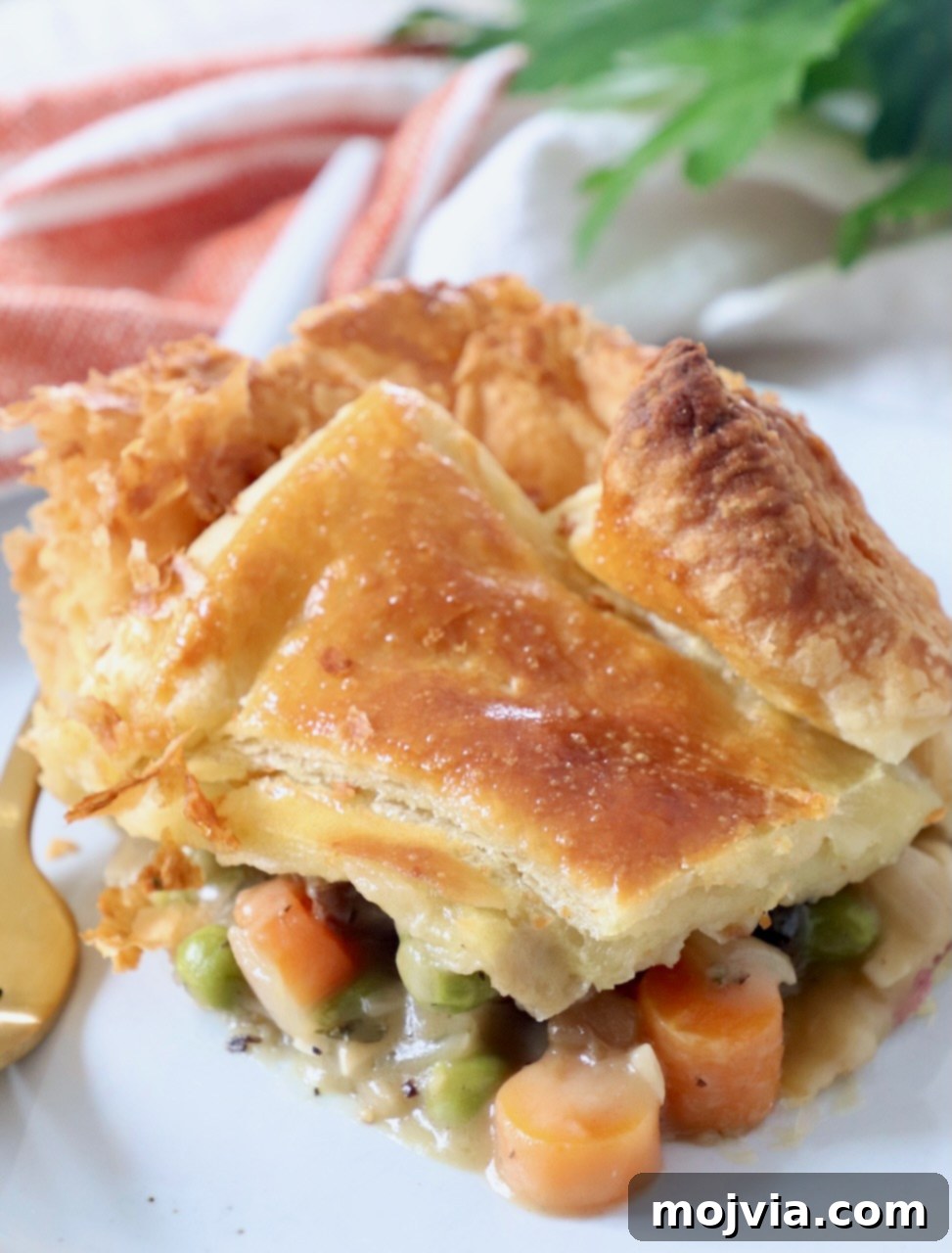Rustic Vegetable Pot Pie 2 piece of vegetable pot pie on plate with fork, showing flaky crust and rich filling