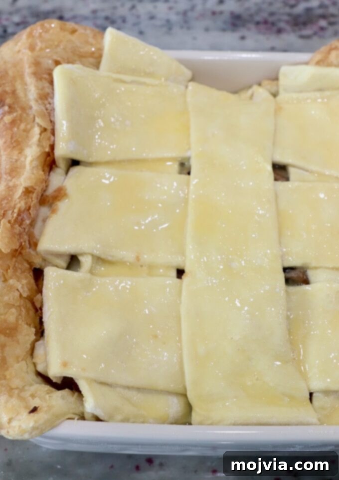 Rustic Vegetable Pot Pie 12 A beautifully woven puff pastry crust topping a vegetable pot pie in a square dish, ready for the oven