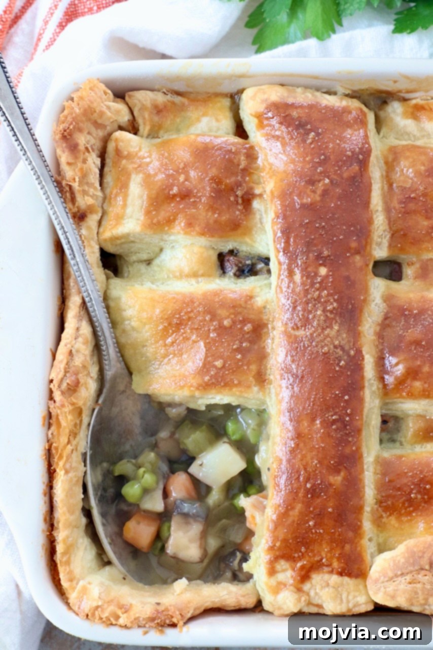 Rustic Vegetable Pot Pie 13 baked vegetable pot pie in square casserole dish with serving spoon, ready to be dished out