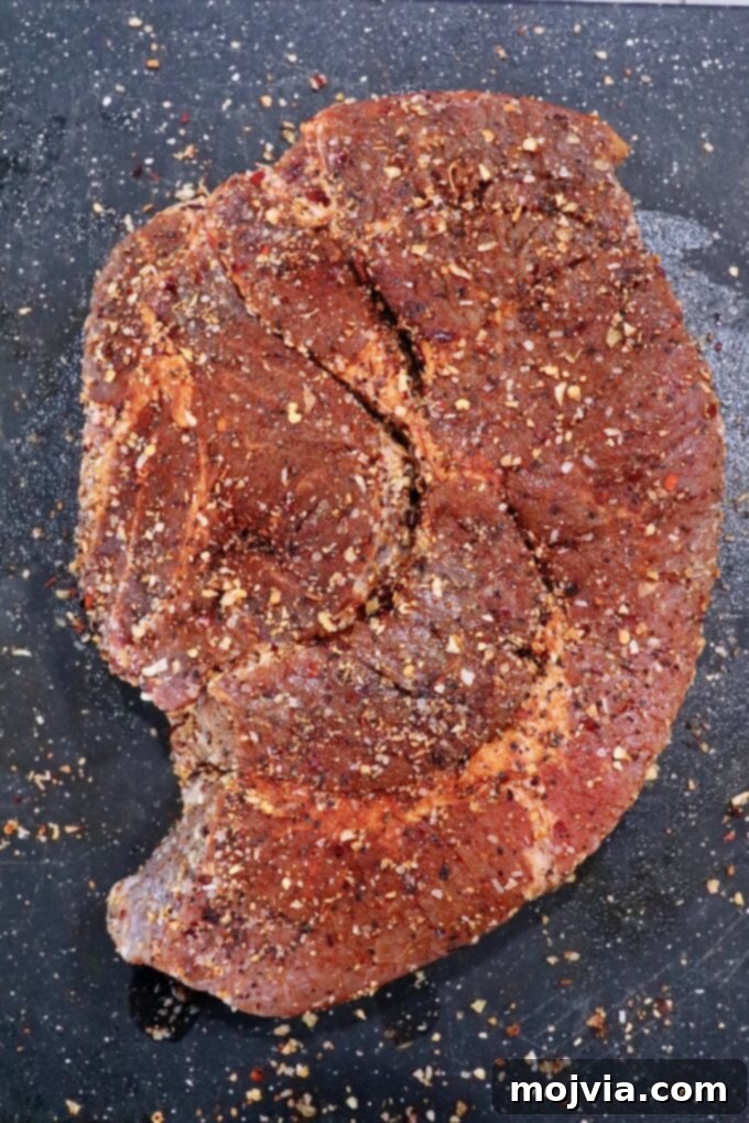 Smoked Beef Chuck Roast Perfection 4 A generously seasoned chuck roast resting on a cutting board, ready for the smoker.