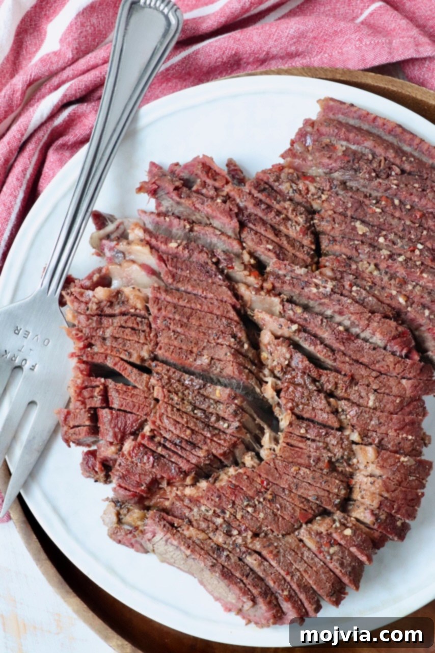 A plate featuring perfectly sliced, juicy smoked chuck roast with a serving fork, ready to be enjoyed.