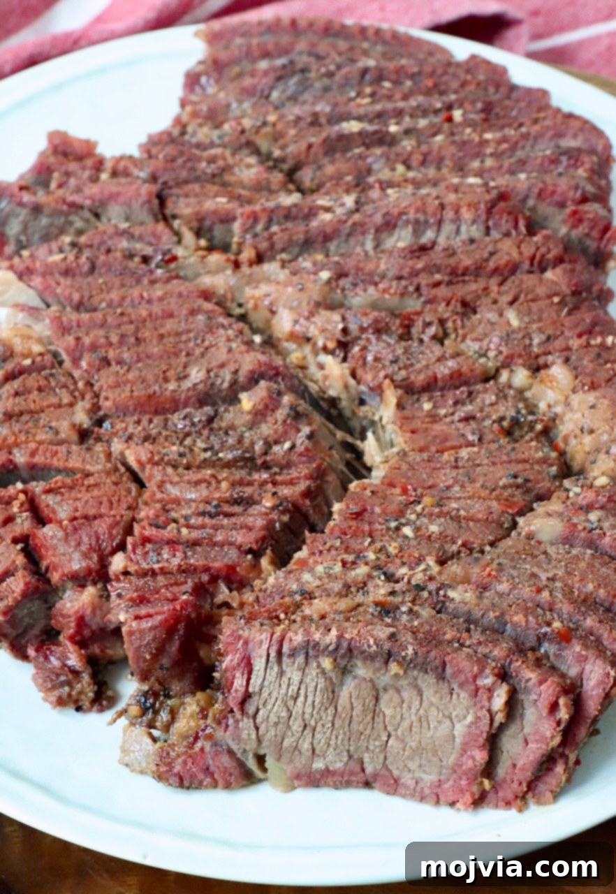 Smoked Beef Chuck Roast Perfection 10 Beautifully smoked chuck roast, thinly sliced and arranged on a plate, ready to be enjoyed.