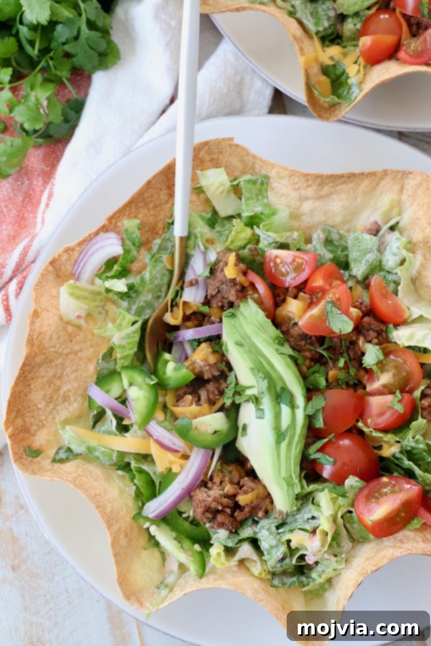 Hearty Beef Taco Salad 11 A delicious taco salad, showcasing fresh ingredients and a crispy tortilla bowl, with a fork poised to enjoy.