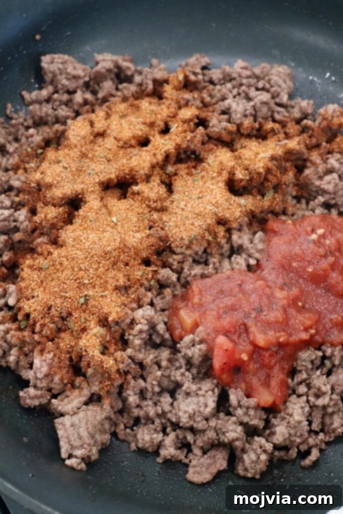 Hearty Beef Taco Salad 6 Close-up of cooked ground beef simmering in a skillet, infused with taco seasoning and a splash of salsa, creating rich and aromatic taco meat.