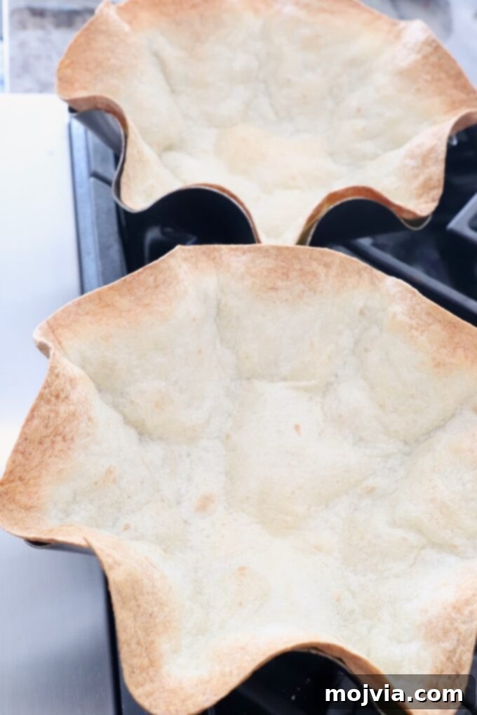 Hearty Beef Taco Salad 9 Golden-brown, perfectly crispy baked tortilla bowls, fresh out of the oven and ready to be filled with delicious taco salad.
