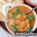 prepared Indian butter paneer in white bowl with copper spoon