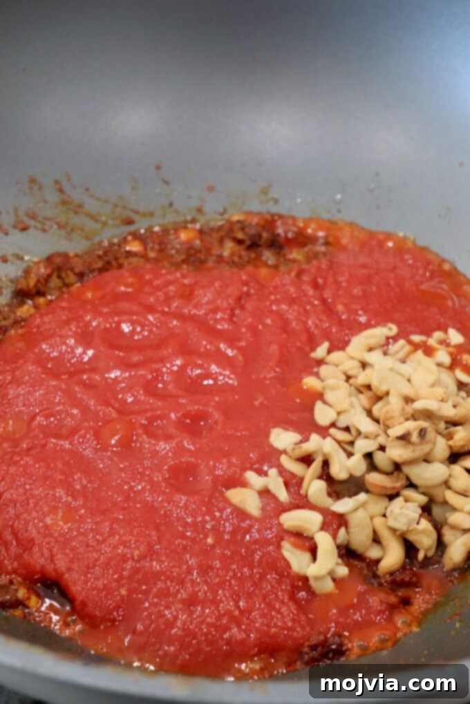Buttery Paneer Indulgence 6 crushed tomatoes in large skillet with cashews