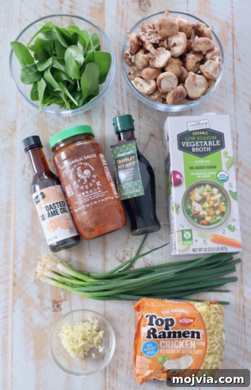 Plant-Based Ramen Perfection 3 Ingredients for vegetarian ramen laid out on a white wooden board, including fresh shiitake mushrooms, bottles of soy sauce and sesame oil, chili garlic sauce, fresh garlic cloves, and ramen noodle packets.