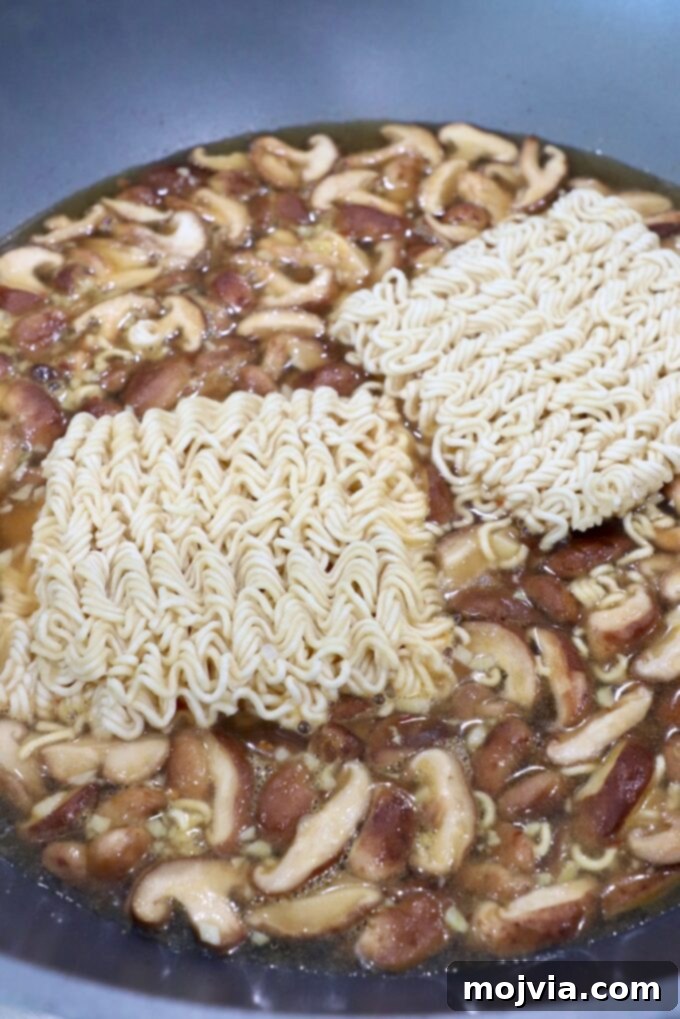 Plant-Based Ramen Perfection 5 Ramen noodles submerged in a rich, simmering broth with sautéed mushrooms and spinach in a large pot on the stove, nearing completion.