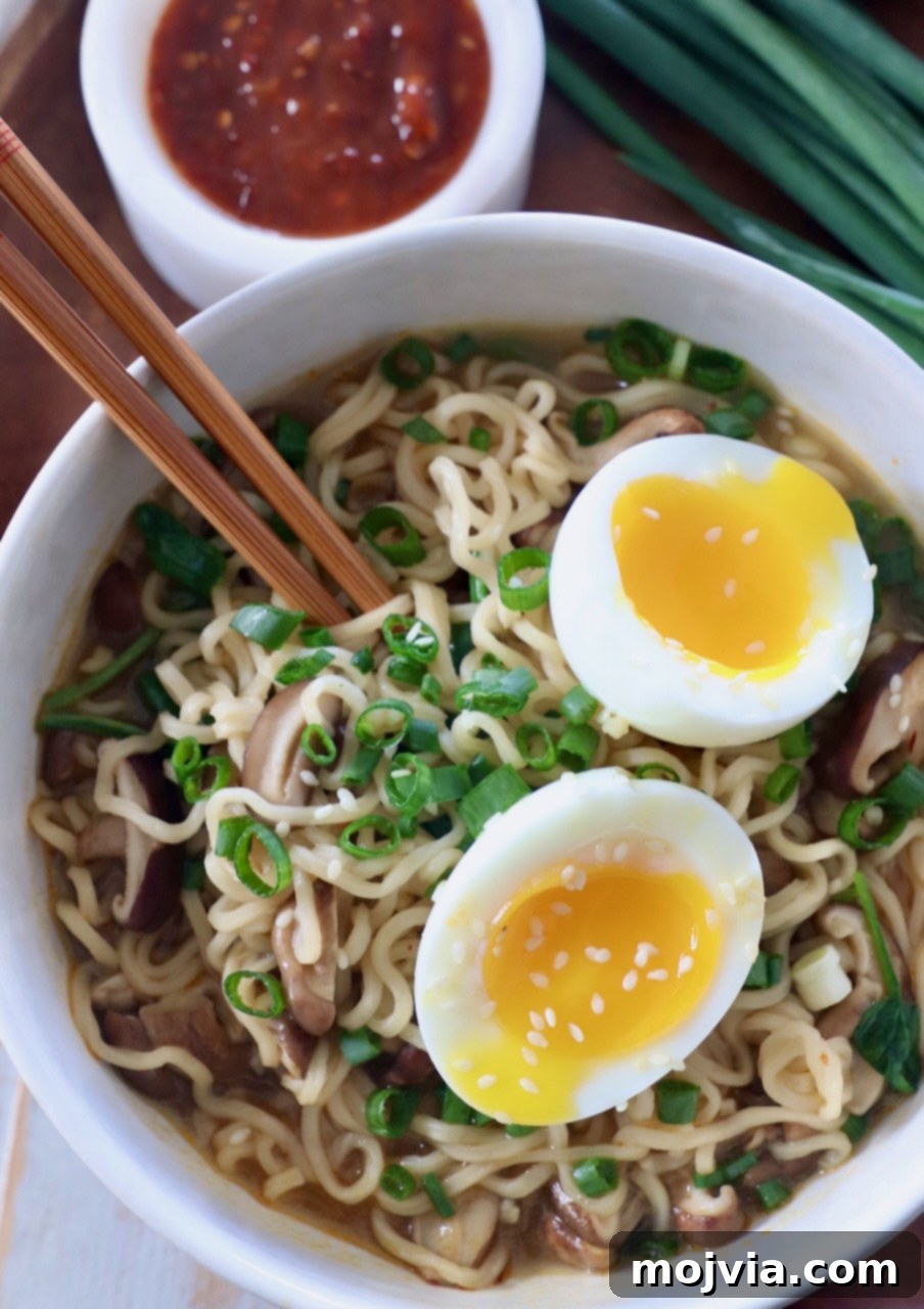 Plant-Based Ramen Perfection 7 A beautifully presented bowl of vegetarian ramen with a soft-boiled egg, surrounded by vibrant green onions, ready to be enjoyed. Chopsticks are held above the bowl.