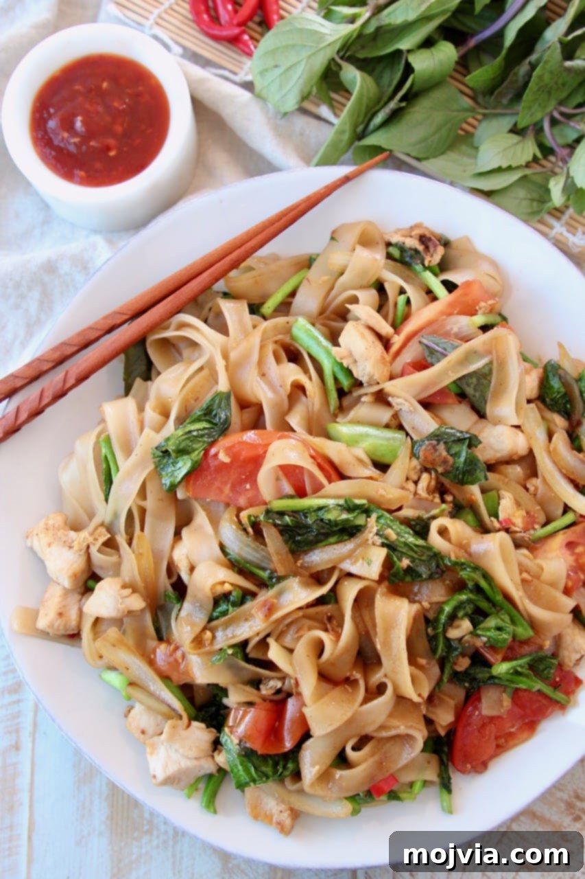 THAI BASIL: A CULINARY GUIDE 3 Overhead shot of Drunken Noodles on white plate with brown chopsticks on the side