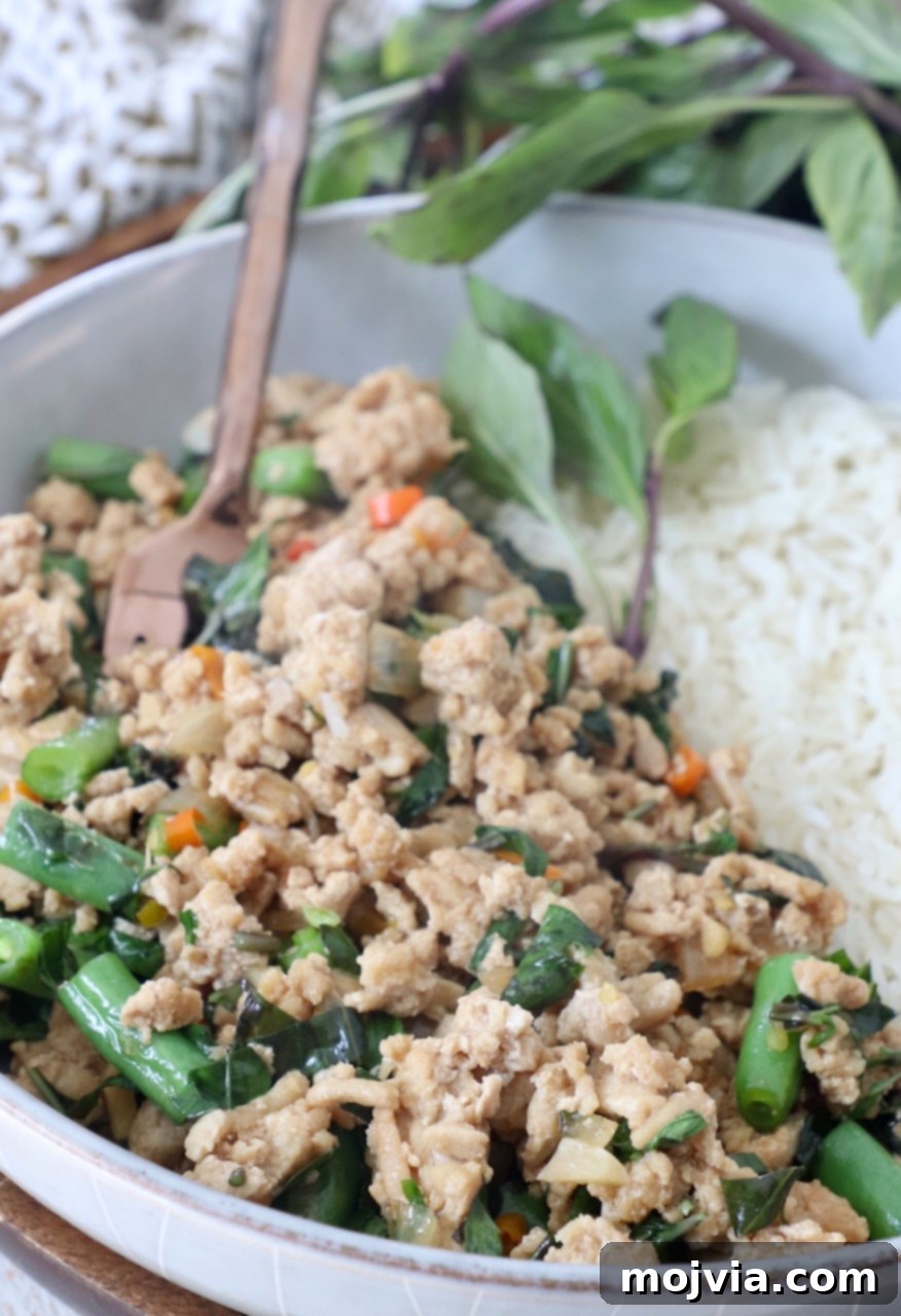 Spicy Thai Basil Chicken Stir-fry 8 Cooked Thai Basil Chicken in a bowl, accompanied by white rice, ready to be served as a delightful and quick meal.