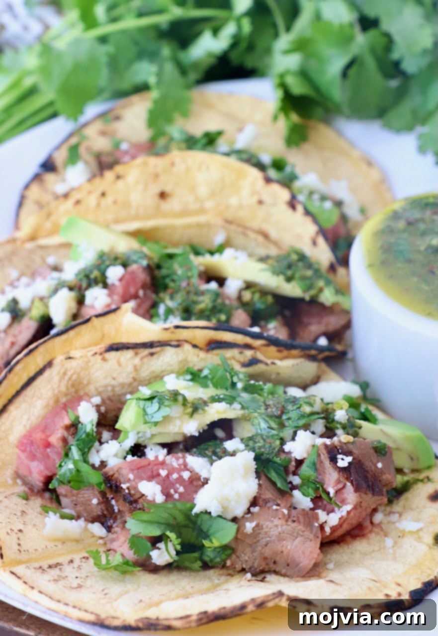Sizzling Flank Steak Tacos 12 grilled steak in tacos on plate topped with cilantro and avocado
