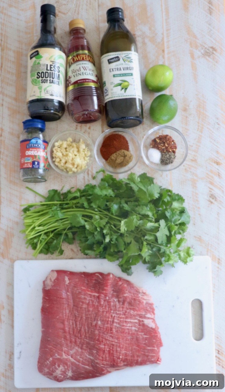 Sizzling Flank Steak Tacos 3 flank steak taco ingredients on white wood board