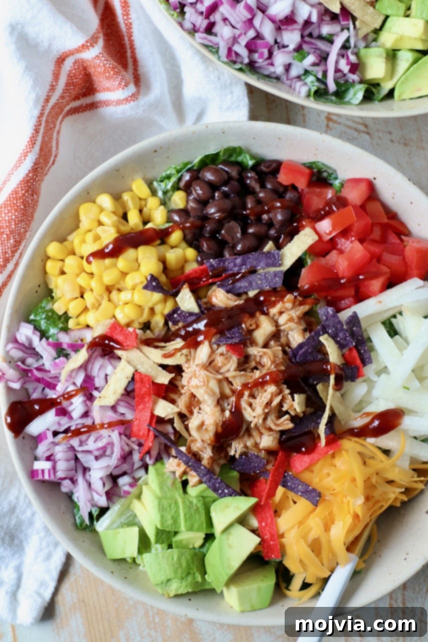 Another view of a BBQ Chicken Salad in a bowl with a fork, emphasizing fresh ingredients.