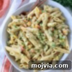 Refreshing Greek Yogurt Pasta Salad 7 Prepared pasta salad in a bowl with serving forks, showcasing its creamy texture