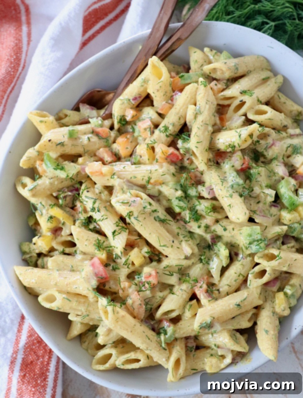 Refreshing Greek Yogurt Pasta Salad 6 Creamy curry pasta salad in a beautiful bowl with serving forks, ready for a meal