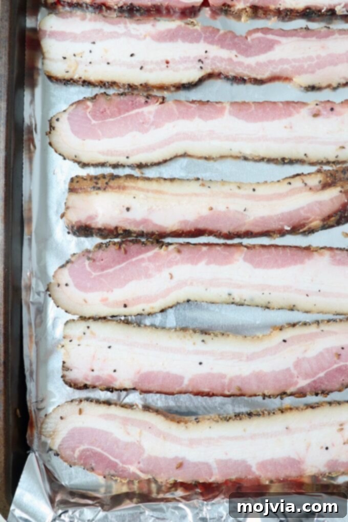 sliced bacon on foil-lined baking sheet