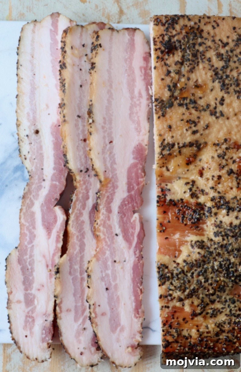 sliced bacon from a smoked pork belly on cutting board