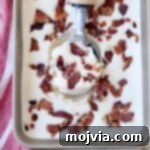 Maple Bacon Ice Cream in a metal container with a scoop.