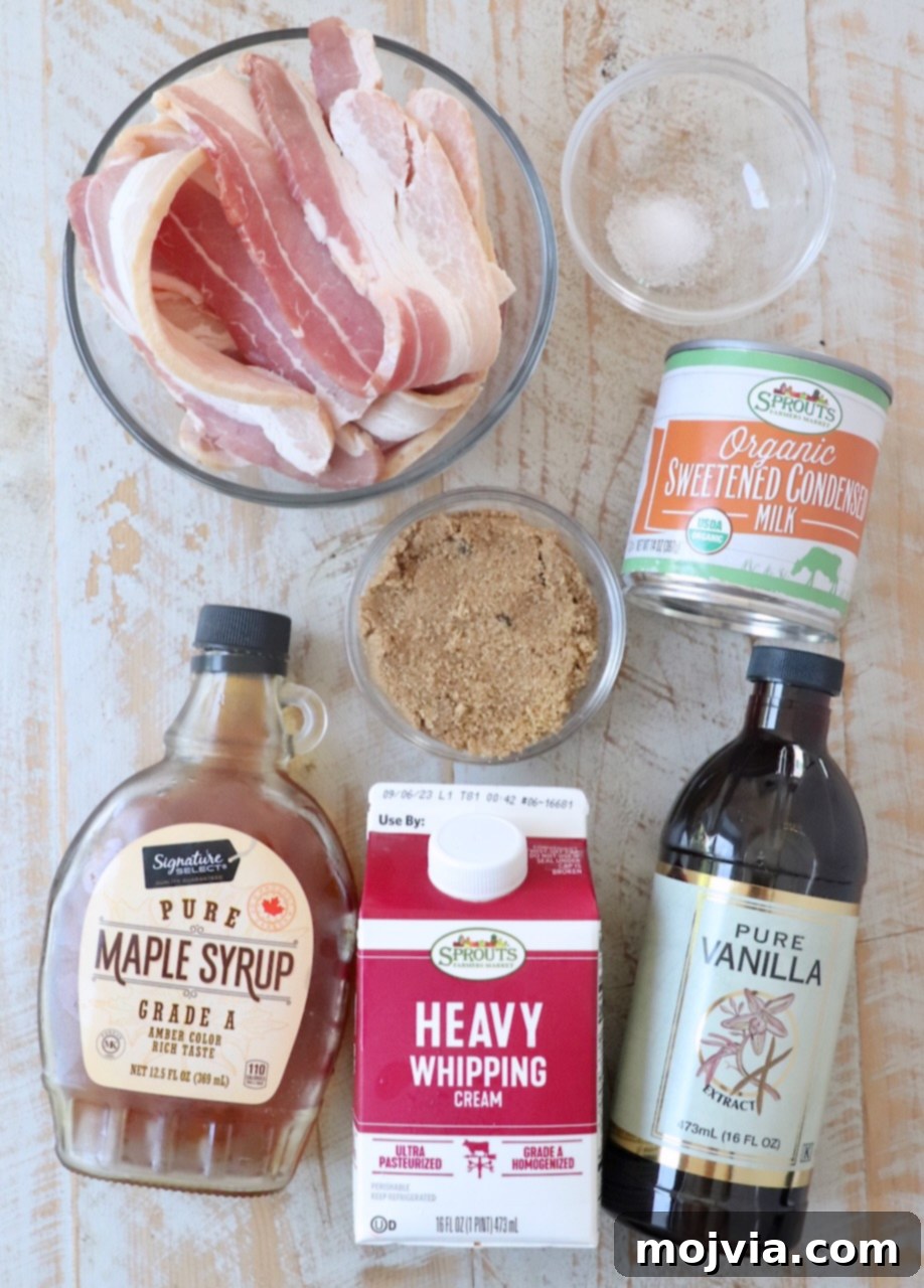 Maple Bacon No-Churn Ice Cream 3 Maple bacon ice cream ingredients laid out on a white wooden board, including thick-cut bacon, maple syrup, brown sugar, sweetened condensed milk, vanilla extract, sea salt, and heavy cream.