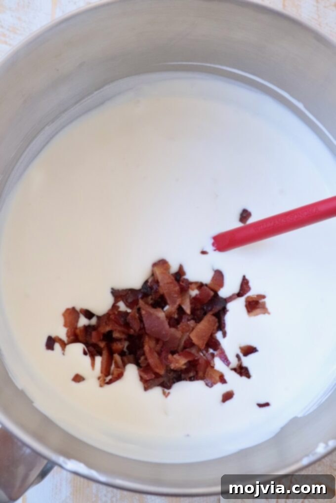 Maple Bacon No-Churn Ice Cream 7 Chopped candied bacon being gently folded into the prepared ice cream base.