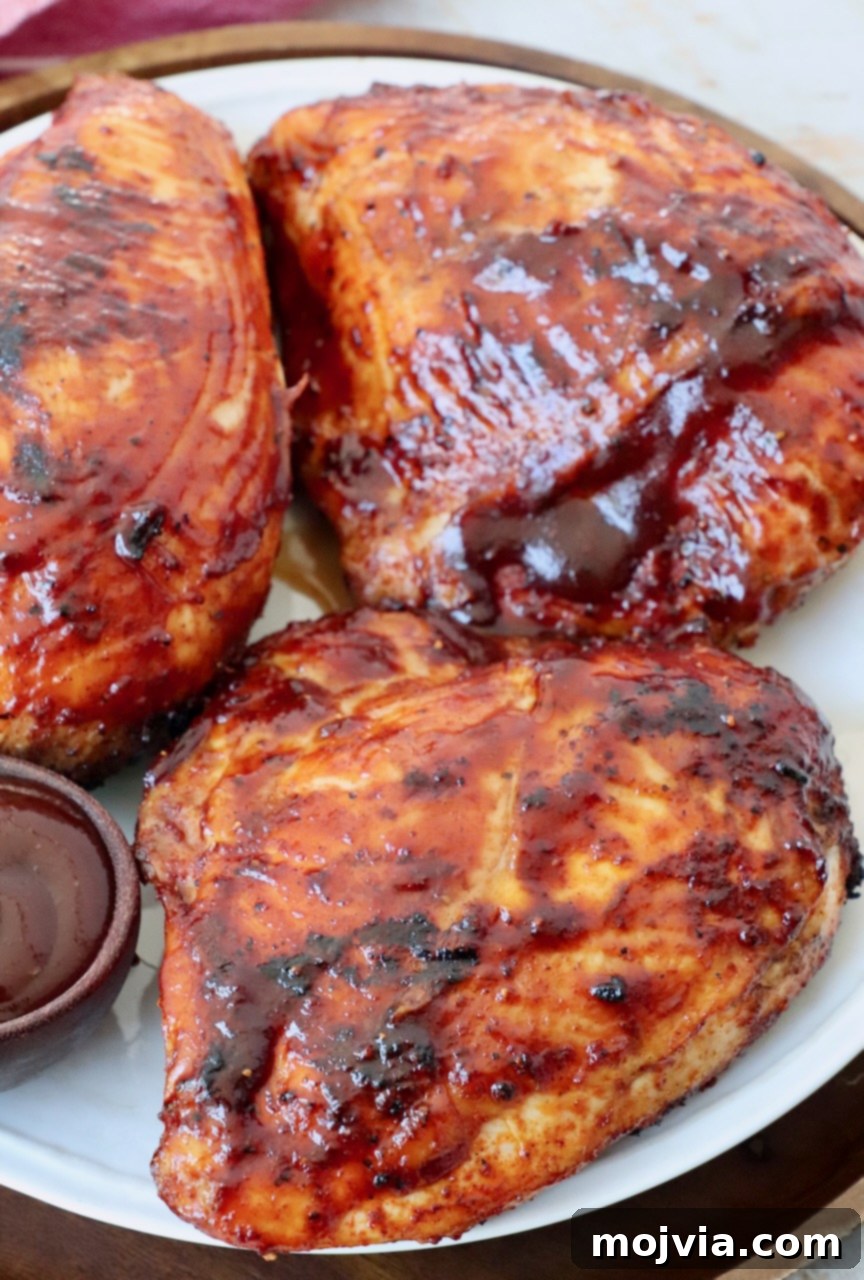 Smoked Chicken Feast 2 Platter of golden-brown grilled bone-in BBQ chicken breasts, legs, and thighs, glistening with barbecue sauce.