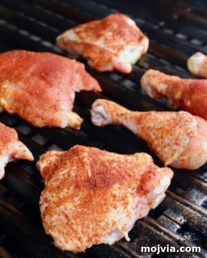 Smoked Chicken Feast 6 Seasoned bone-in chicken pieces placed on the unheated side of a grill, beginning the indirect cooking process.