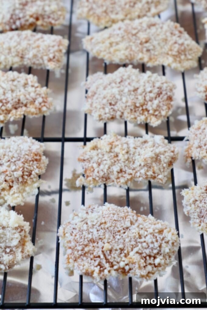 Crispy Boneless Bites 12 uncooked breaded chicken pieces on wire rack on top of foil-lined baking sheet