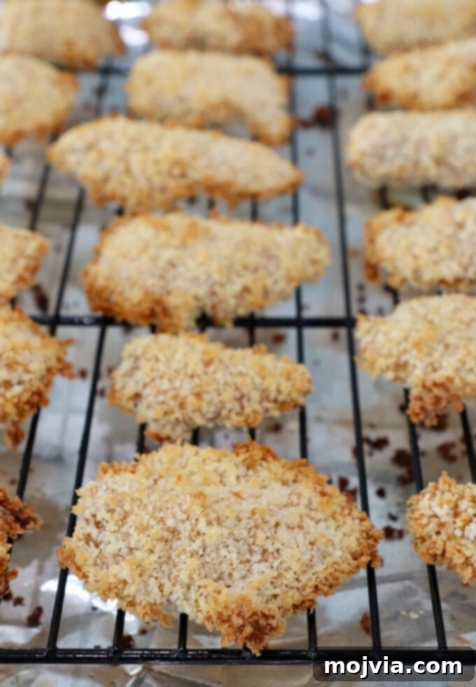 Crispy Boneless Bites 13 cooked, breaded pieces of chicken on wire rack on top of baking sheet