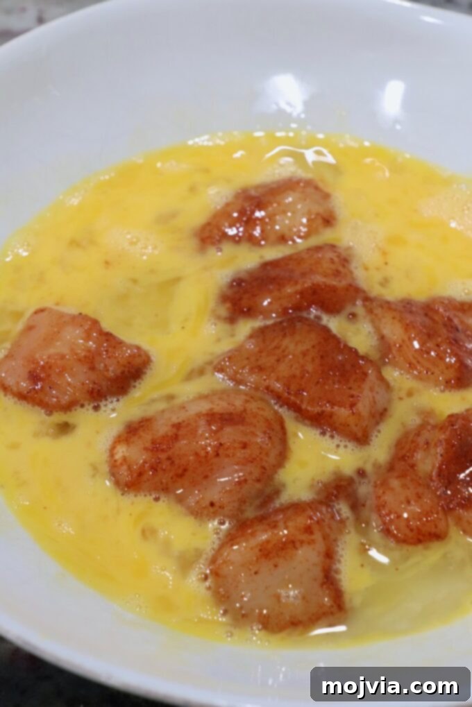 Crispy Boneless Bites 6 seasoned pieces of chicken breast in bowl of whisked eggs