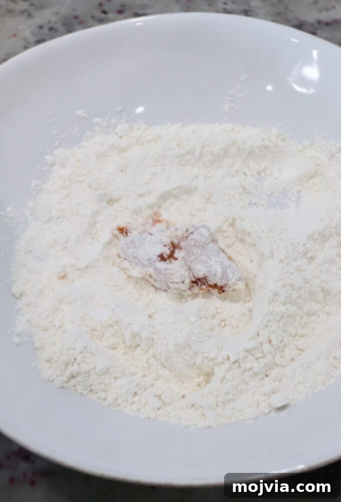 Crispy Boneless Bites 7 piece of chicken breast covered in flour in bowl