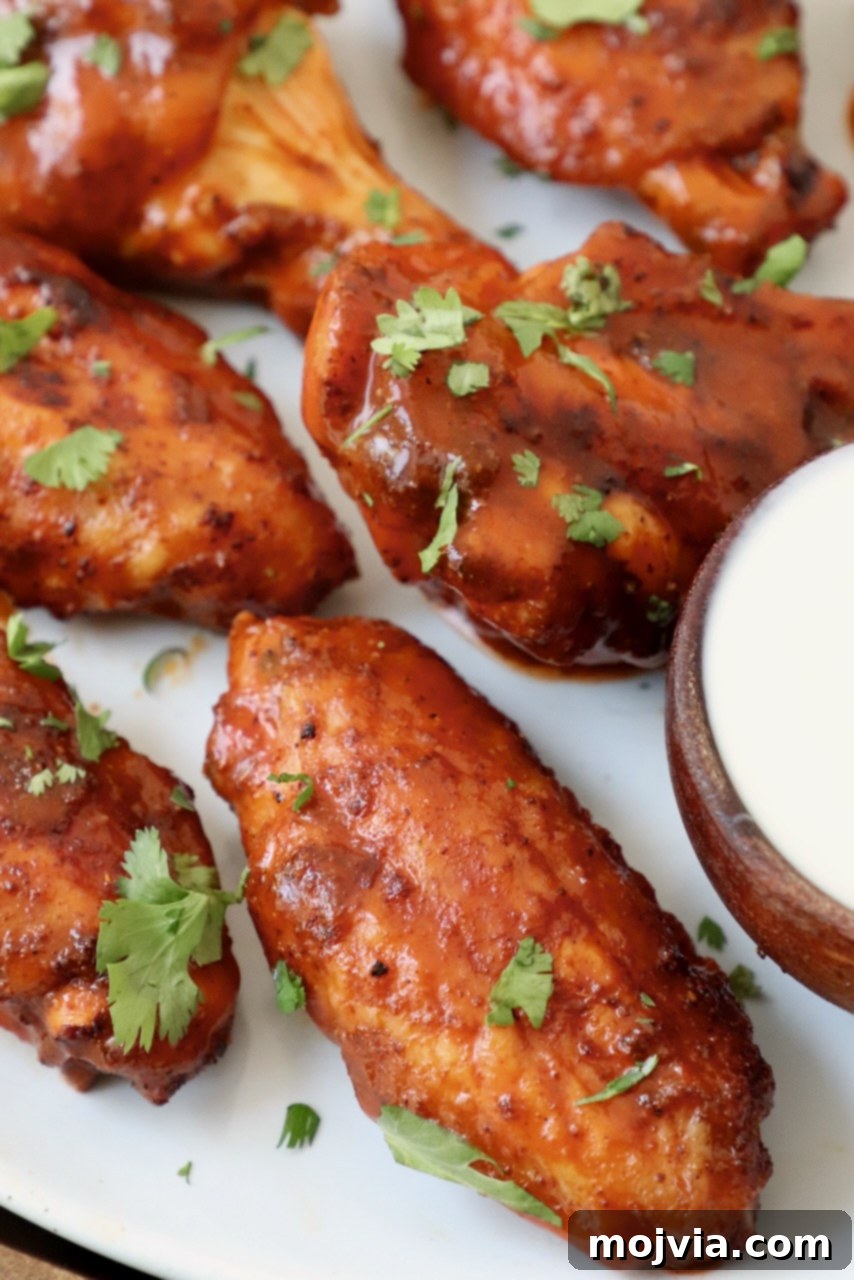 Ultimate Smoked Chicken Wings 2 smoked chicken wings tossed in buffalo sauce on plate