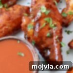 Ultimate Smoked Chicken Wings 10 smoked chicken wings on plate tossed with buffalo sauce