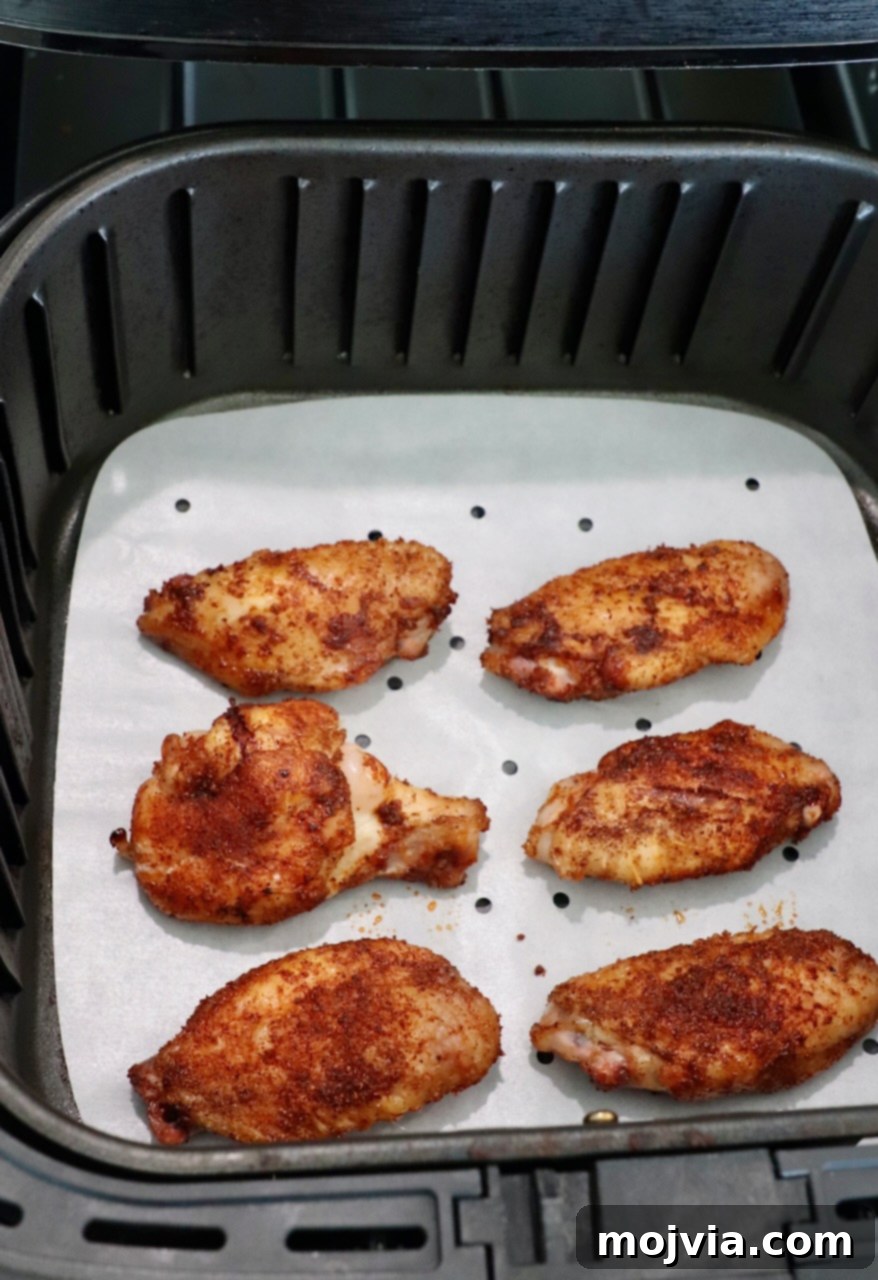 Ultimate Smoked Chicken Wings 8 seasoned, smoked chicken wings in air fryer basket