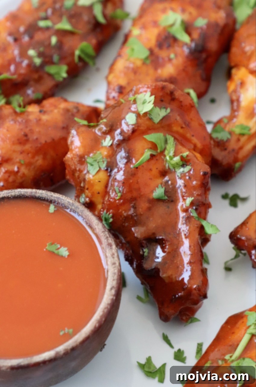 Ultimate Smoked Chicken Wings 9 cooked chicken wings tossed in buffalo sauce on plate