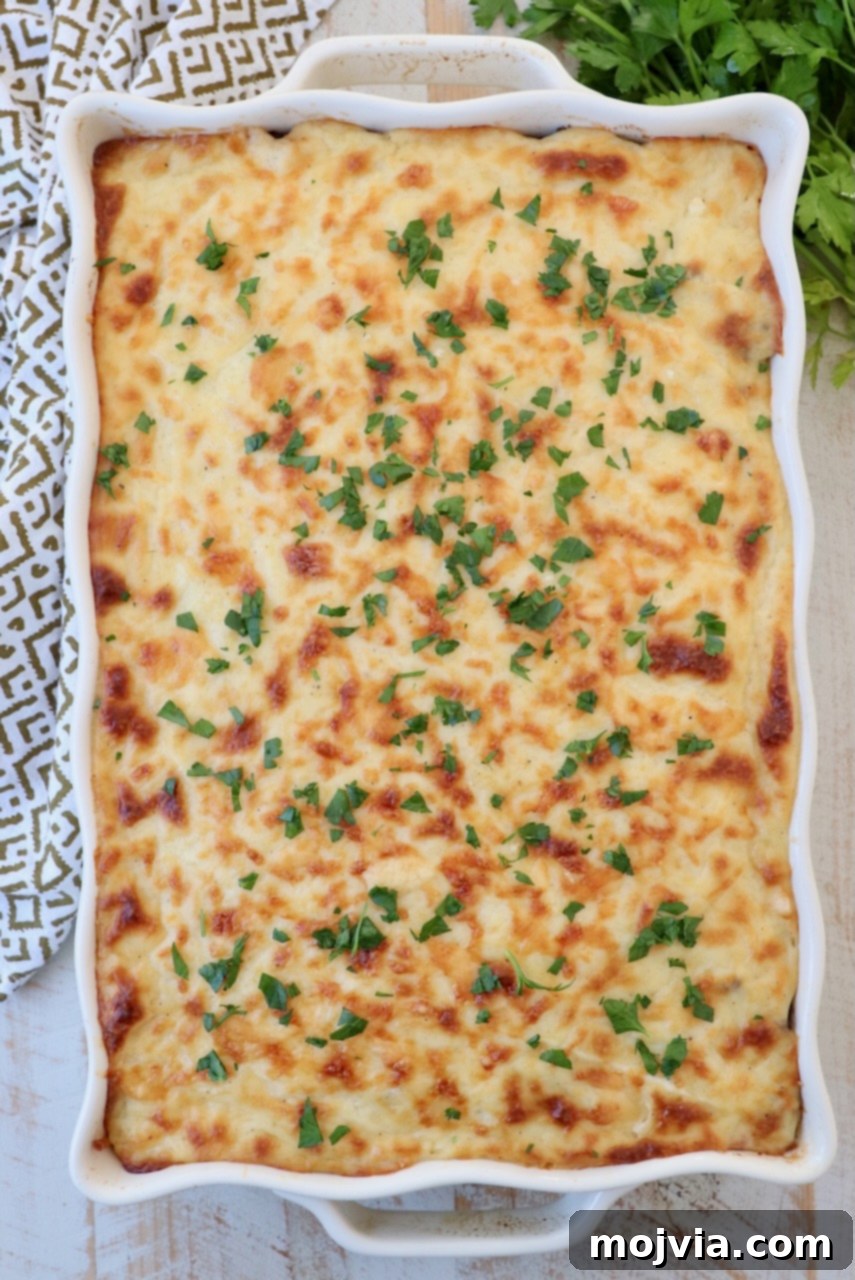 Creamy Greek Comfort Bake 15 The beautifully baked Pastitsio in a large casserole dish, fresh out of the oven, with a golden-brown, bubbling béchamel topping.