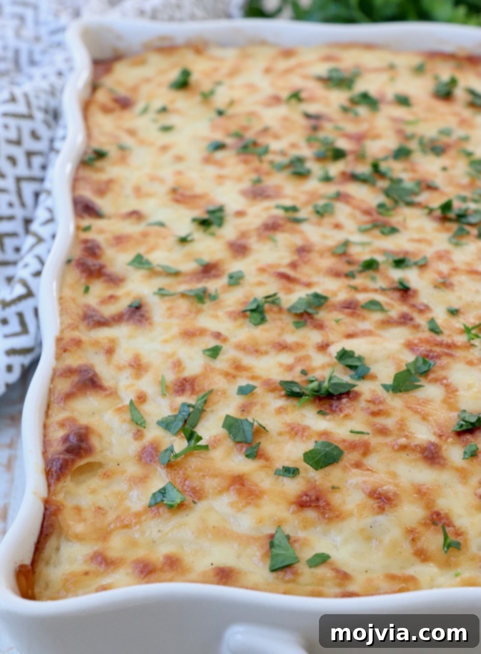 Creamy Greek Comfort Bake 17 A close-up shot of the baked Pastitsio still in its casserole dish, highlighting the golden-brown béchamel topping and inviting texture.