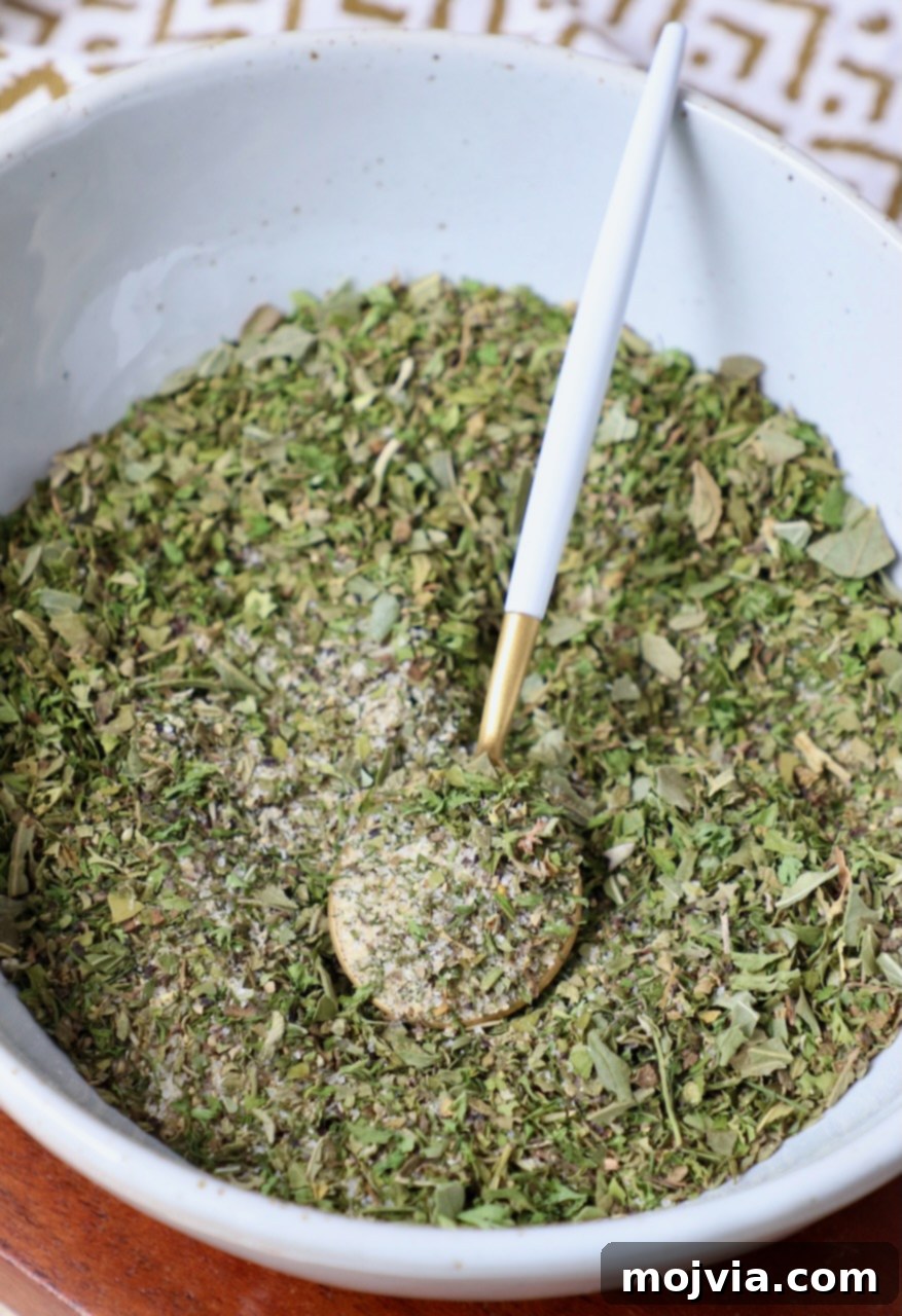 Hellenic Flavor Booster 4 Greek seasoning combined in a bowl with a small spoon