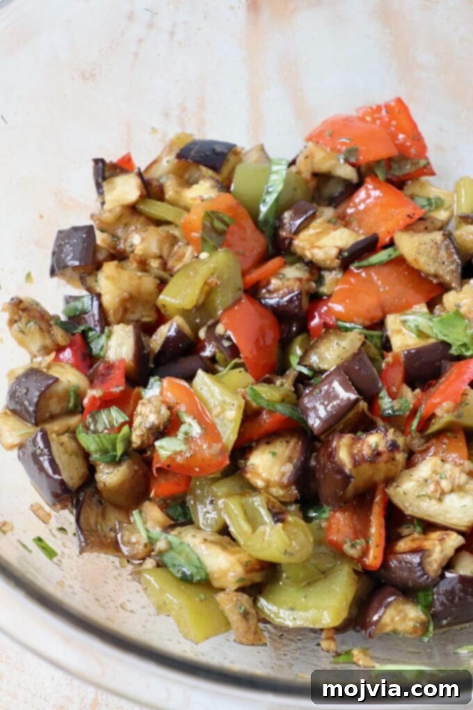 Smoky Eggplant Salad 5 roasted eggplants and bell peppers tossed with balsamic dressing in large glass bowl