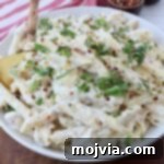 garlic parmesan chicken pasta in bowl with serving spoon