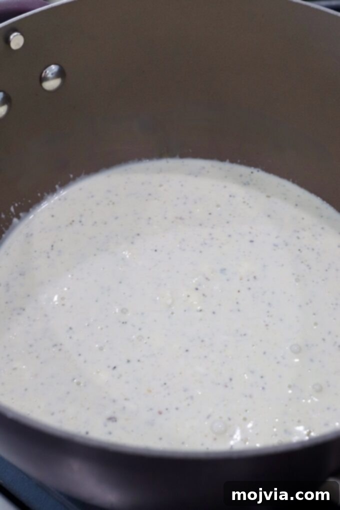 garlic parmesan white sauce simmering in a saucepan